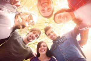 Make A difference, Today and Always Group of young people in a circle looking down at the camera in the center of the pic